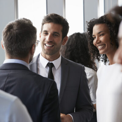 A commercial mortgage broker greets another at an informal networking event